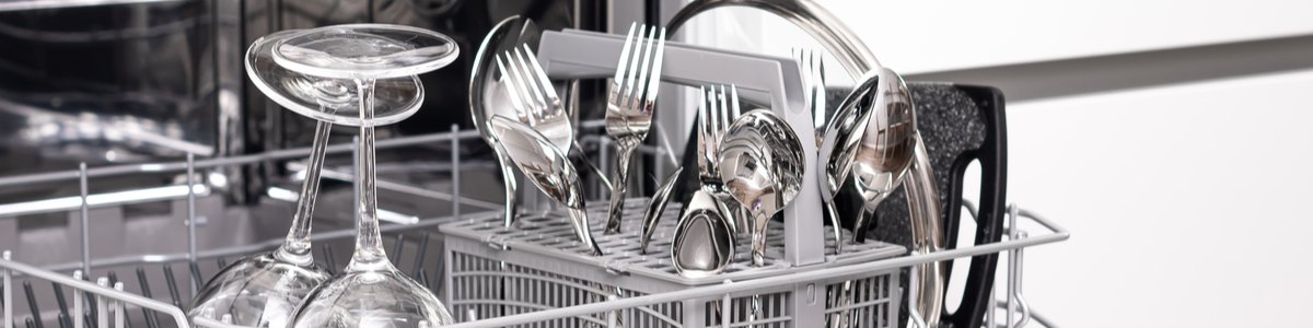 Dishwasher drawer open with cutlery and plates