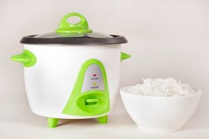Small rice cooker and a bowl of white rice.