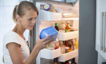 woman looking through fridge