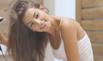 woman-drying-hair-in-mirror