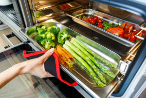 Vegetables being taken out of a steam oven