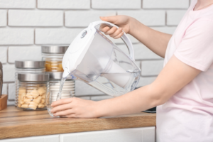 Woman pouring water from a water filter jug