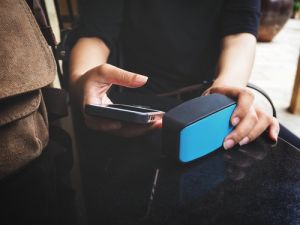 Woman using smart phone with bluetooth speaker