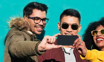 Group of friends taking group selfie with smartphone