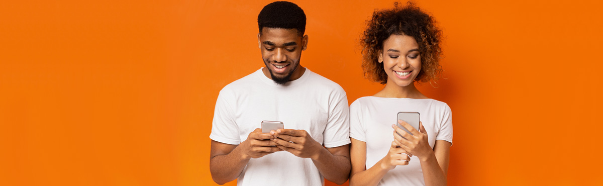 Young adults using phones against orange background