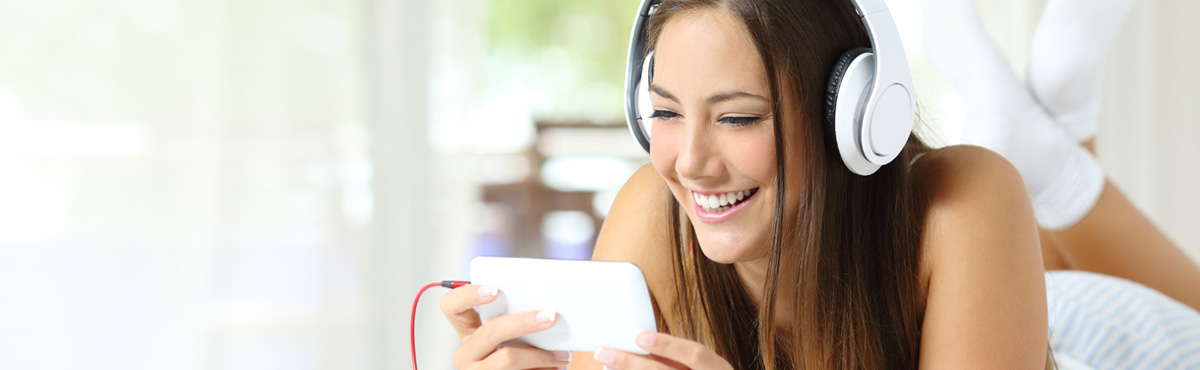 Young woman wearing headphones watching video on her phone