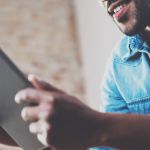 Young man holding tablet using internet on device