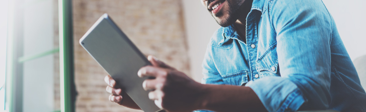 Young man holding tablet using internet on device