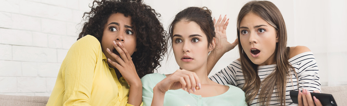 Group of young women scared while watching horror movie