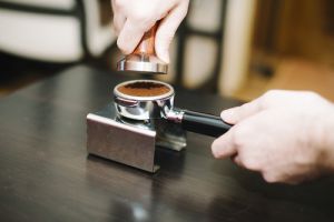 man tamping coffee