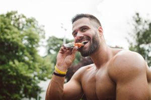 Bodybuilder eating protein bar