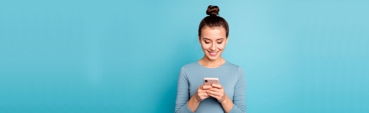 young woman holding phone with blue background