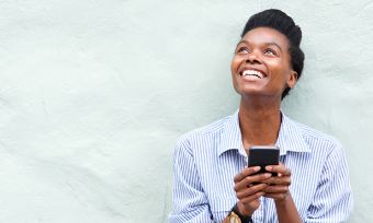 Young woman holding phone. Are Optus phones unlocked?