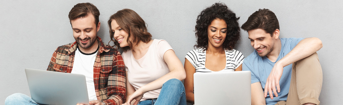 Group of four young people looking at laptop screens