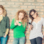 Group of young people looking at their mobile phones