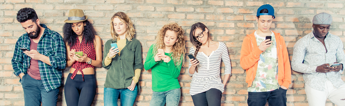 Group of young people looking at their mobile phones