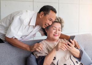 Elderly couple looking at smartphone together in lounge room