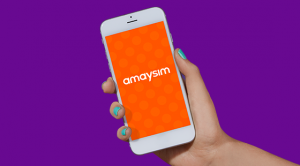 Hand holding phone with amaysim logo on purple background