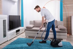 Young Man Cleaning Blue Carpet 