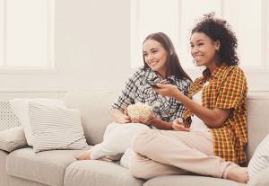 Two young women watching TV together