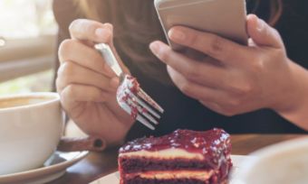 Woman eating food while on phone