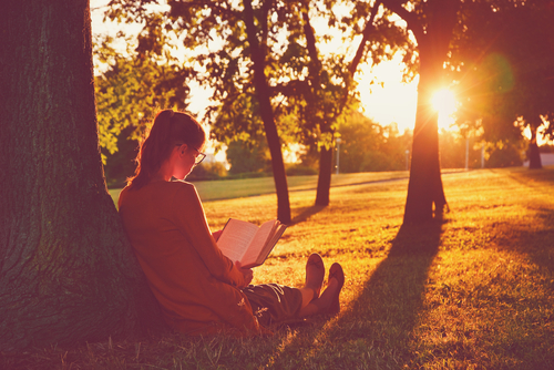 Woman reading book in shade