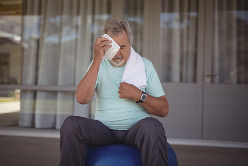 Older man sweating with towel on head