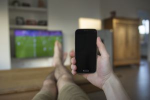 holding phone in front TV