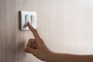 hand turning off light switch 