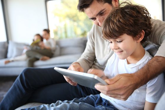 Father and son playing game on tablet