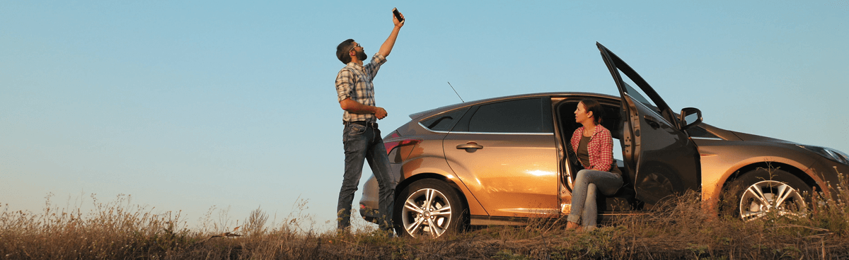 Couple searching for phone signal in mobile black spot