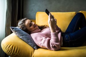 girl sitting on couch phone