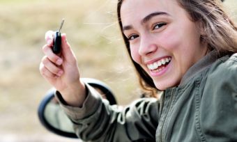 girl holding keys in car