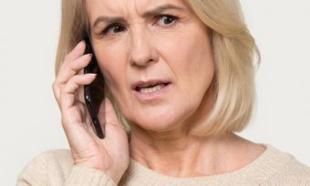 Mature age lady on phone to energy company frustrated