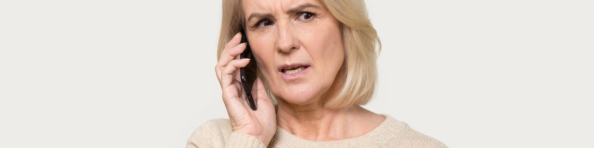 Mature age lady on phone to energy company frustrated
