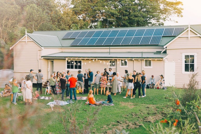 People having bbq in front of house with solar panels