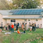 People having bbq in front of house with solar panels