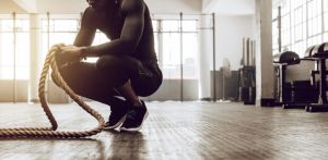 Man with battle ropes in gym