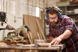 Man in small business with bench saw