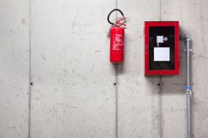 Fire extinguisher in glass case on wall