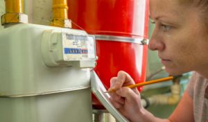 Lady with notepad writing down gas meter reading