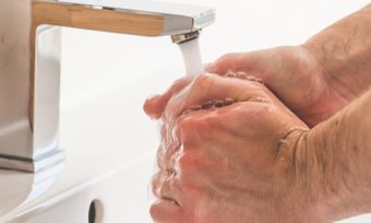 Person washing hands in sink