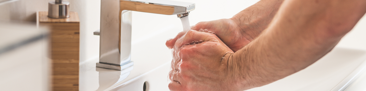 Person washing hands in sink