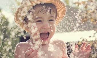 Young boy playing in water in backyard