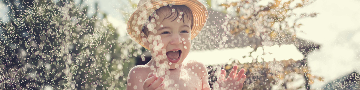 Young boy playing in water in backyard