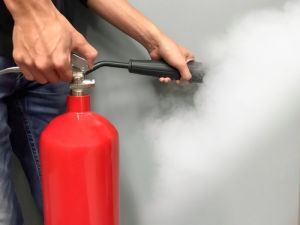 Man holding and using fire extinguisher