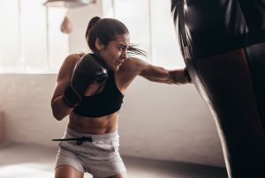 Woman boxing with punching bag