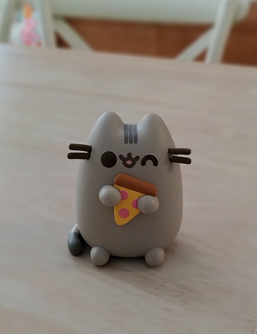 Pusheen the cat holding pizza vinyl figurine