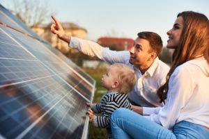 Young parents with child looking at solar panels at home