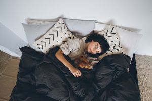 Woman in bed with doona